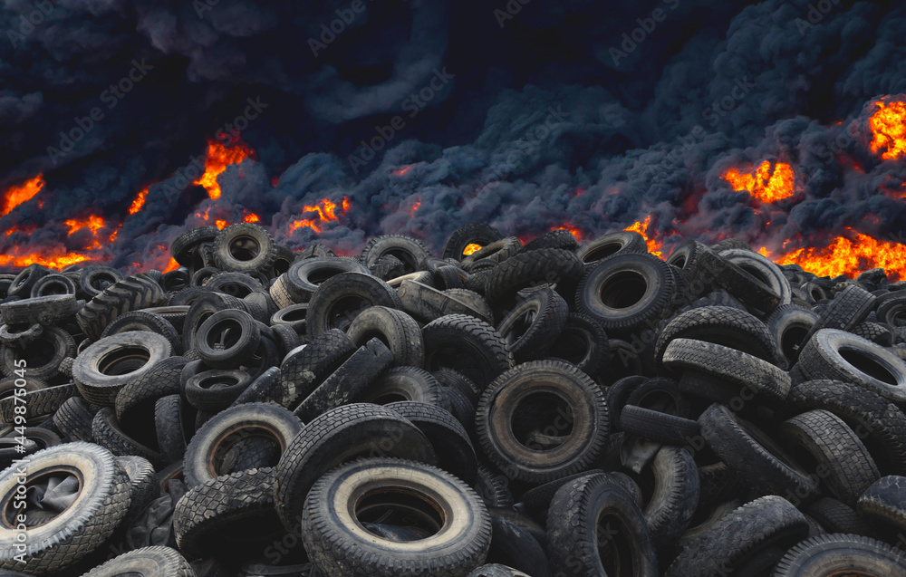 Tyres are on fire. Burning old tyres on recycling landfill. Black smoke