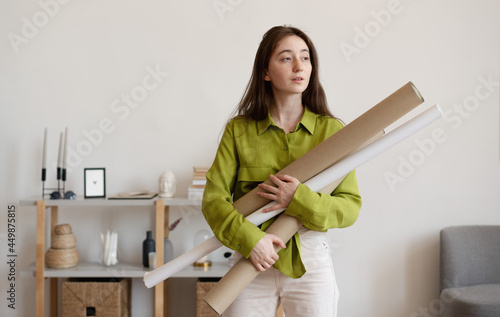 Tableau sur toile Beautiful young woman architect designer holding blueprints
