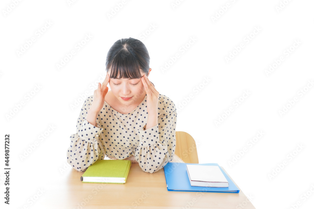 机で勉強をする若い女性 机で勉強をする若い女性