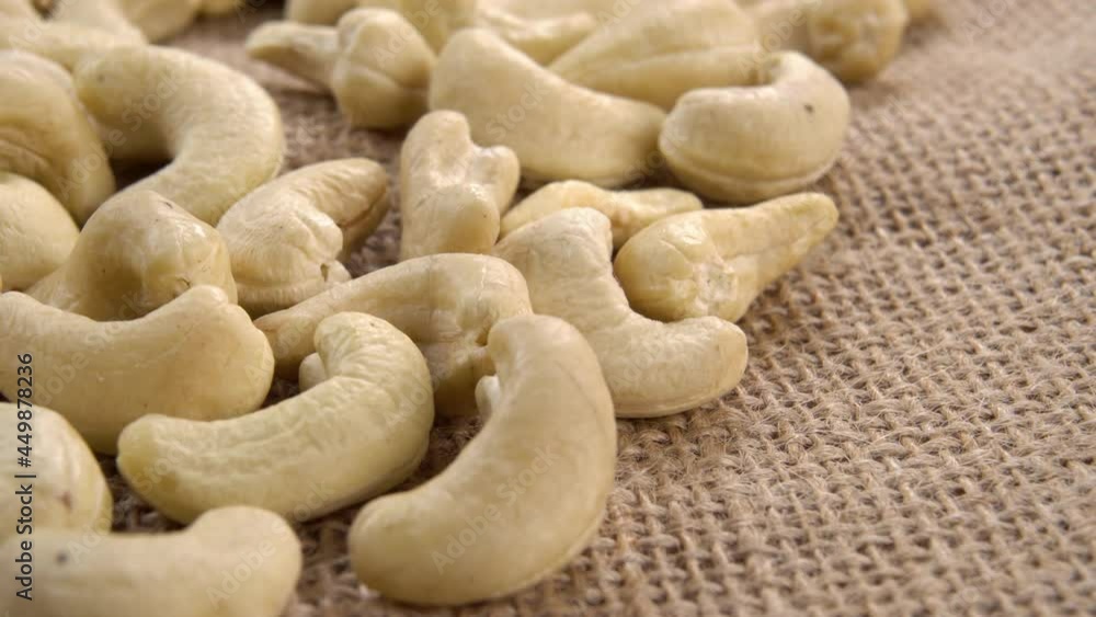 Organic dried cashew nuts on rustic rough burlap. Macro. Dolly shot. Organic dried cashew nuts on rustic rough burlap. Macro. Dolly shot.