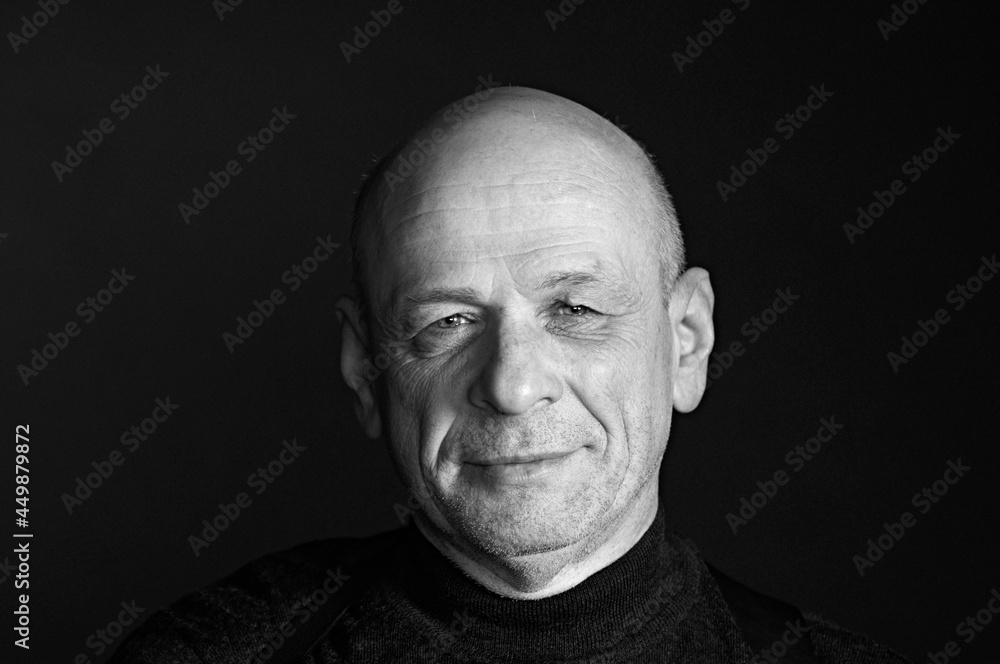 Confident senior man thinking about something. Isolated black background with copy space. Black and White