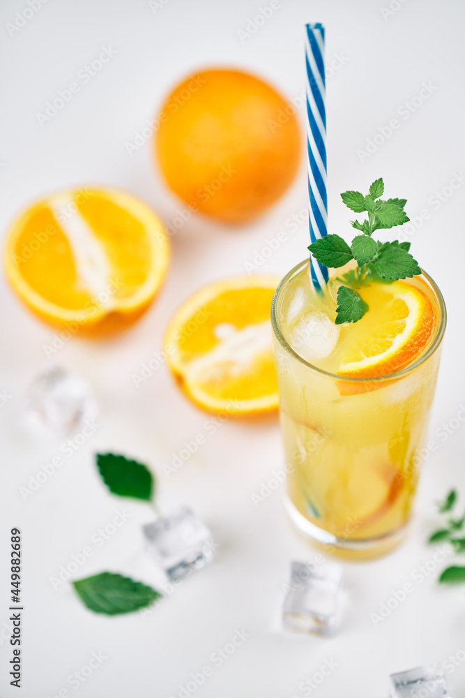Fototapeta premium Cocktail with orange juice, mint and ice cubes on white background