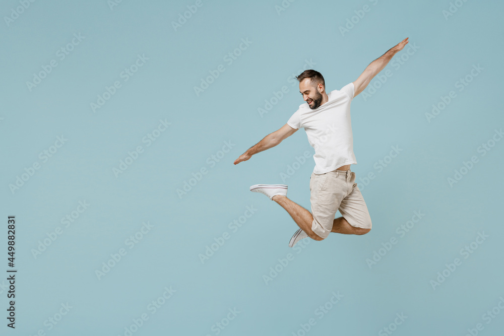 Full length young overjoyed fun cool happy excited caucasian man 20s wear casual white t-shirt jump high with outstretched hands isolated on plain pastel light blue color background studio portrait Full length young overjoyed fun cool happy excited caucasian man 20s wear casual white t-shirt jump high with outstretched hands isolated on plain pastel light blue color background studio portrait