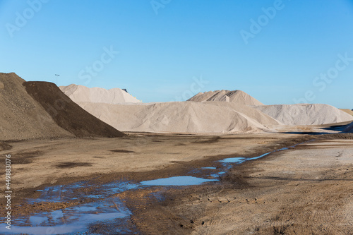 Piles of material line a rock quarry