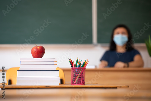 Teacher in the classroom wearing mask. Learning during coronavirus pandemic concept.