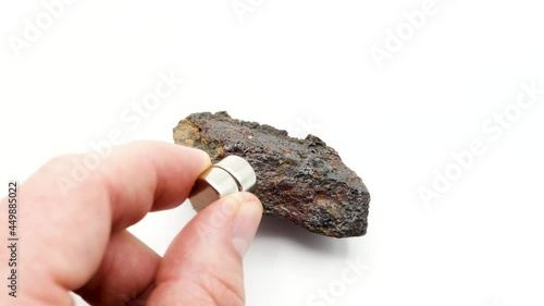 A magnet attracts an iron rock, Ferruginous mass, Iron-rich rock mineral, iron ores, hematite, magnetite, limonite photo
