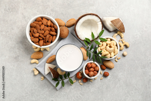 Vegan milk and different nuts on light table  flat lay
