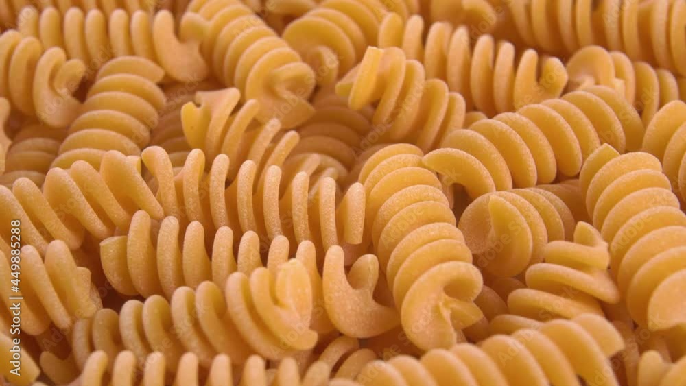Orange lentil pasta. Macro. Rotation. Vegetable spiral uncooked raw dry macaroni Orange lentil pasta. Macro. Rotation. Vegetable spiral uncooked raw dry macaroni
