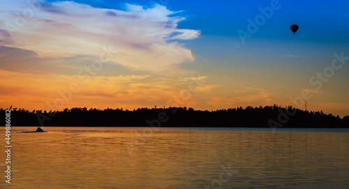 sunset over the lake with airballoon and boat
