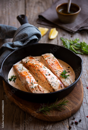 Cooked salmon fish with cream sauce in frying pan