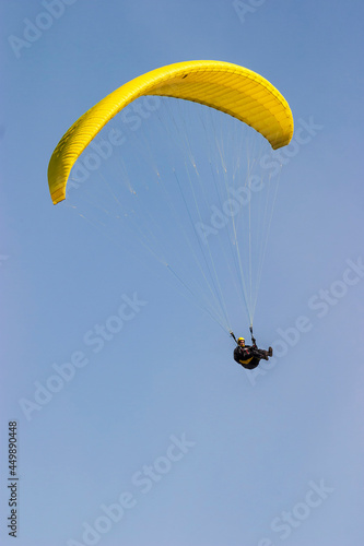 Paraglider flying at a clear blue sky a sunny day