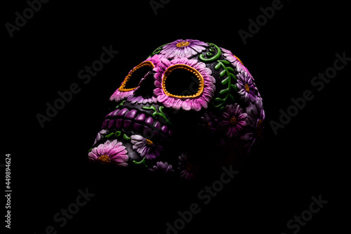 Typical Mexican skull with flowers painted on black background