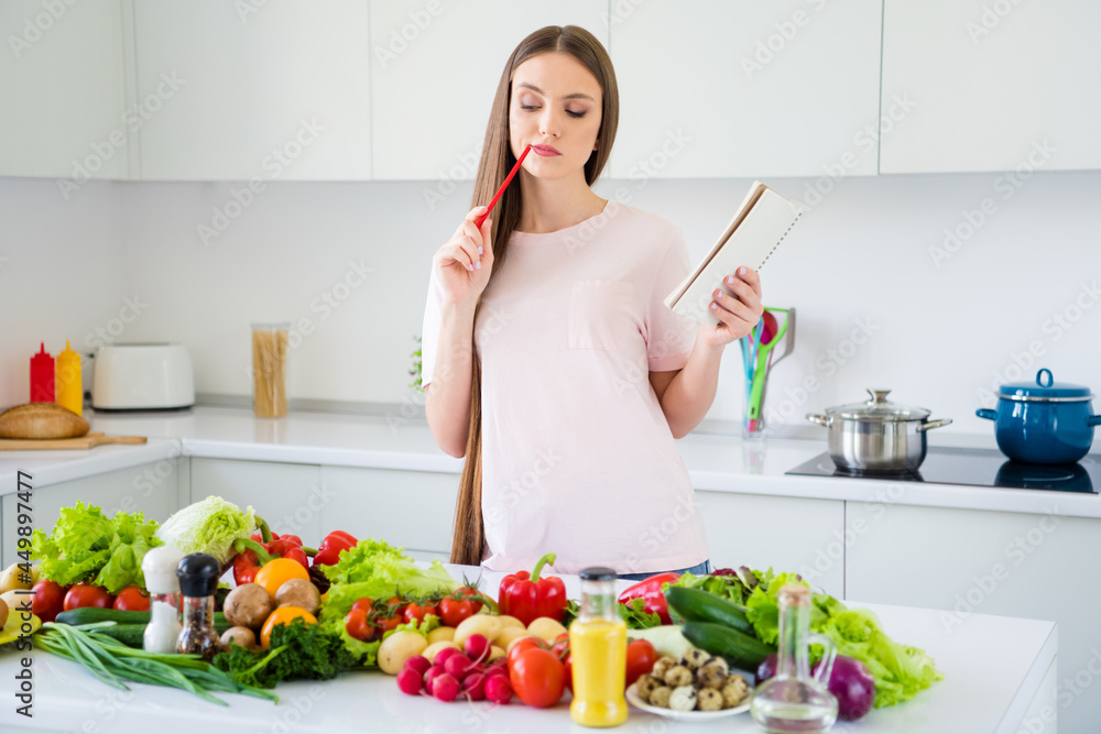 Photo portrait young woman writing notes in blocknote cooking salad