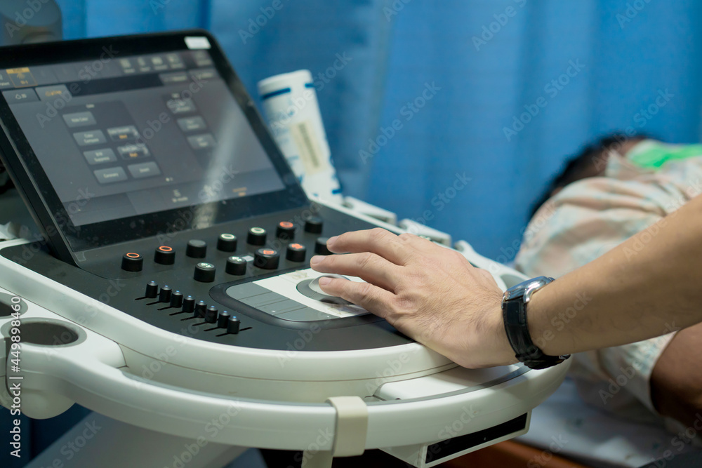 Closeup of man getting an ultrasound scan on abdominal by doctor.