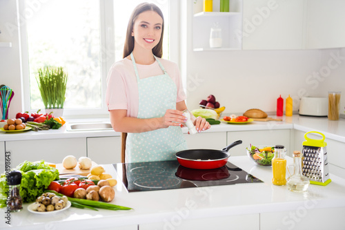 Portrait of attractive cheerful girl cooking fresh homemade meal cuisine enjoying life lifestyle at home light white kitchen indoors