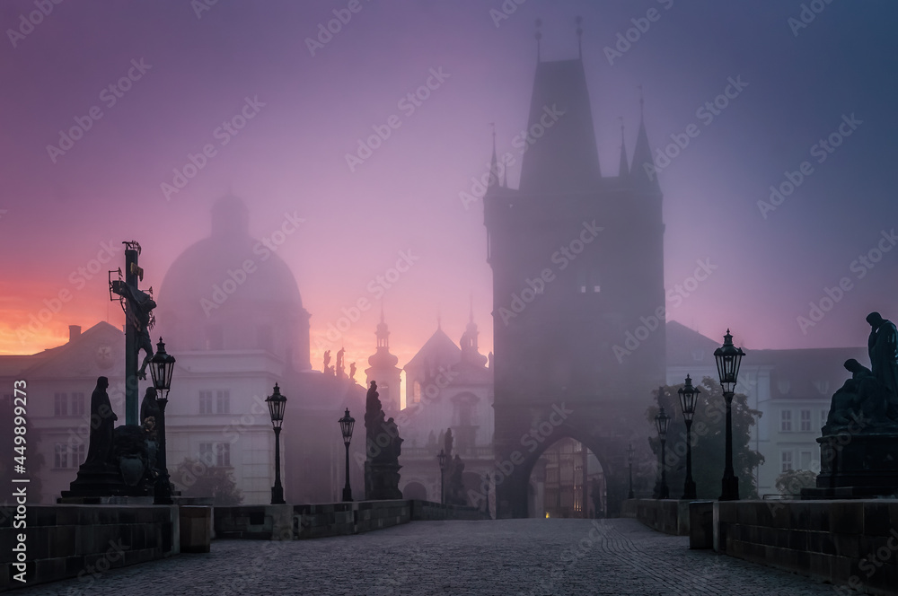 Charles bridge in Prague at foggy morning in Czech Republic.