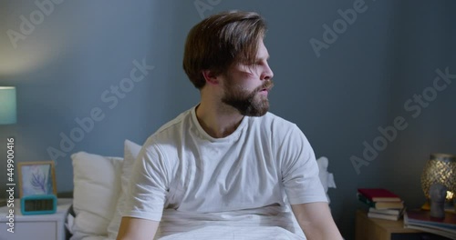 Beautiful Caucasian man waking up through a nightmare. Young male calm down and goes back to sleep.