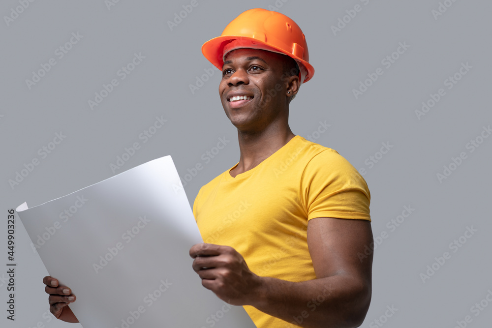 A dark-skinned construction engineer in a protective hemlet A dark-skinned construction engineer in a protective hemlet