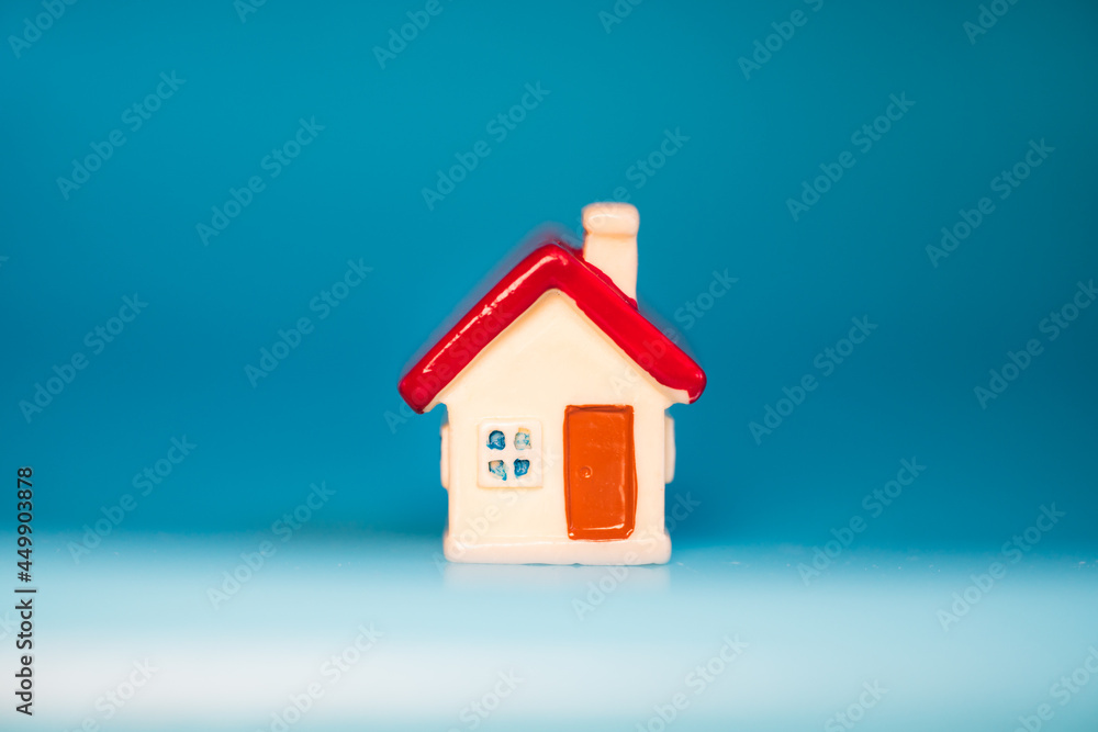 Closeup miniature house on blue background using as property real estate and family concept Closeup miniature house on blue background using as property real estate and family concept