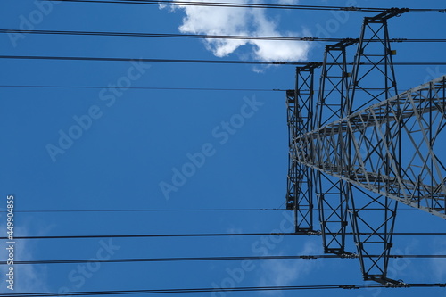 Obraz na plátně low angle view of high voltage power pylon and blue sky