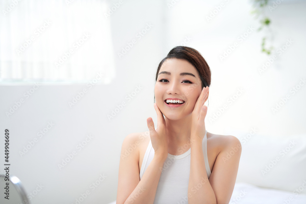 Beauty portrait of a young woman touches the face with even clean skin Beauty portrait of a young woman touches the face with even clean skin