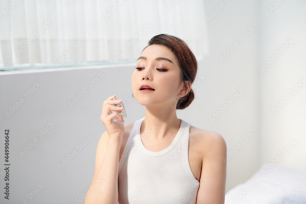 Lady with perfume, young beautiful woman holding bottle of perfume and smelling aroma Lady with perfume, young beautiful woman holding bottle of perfume and smelling aroma