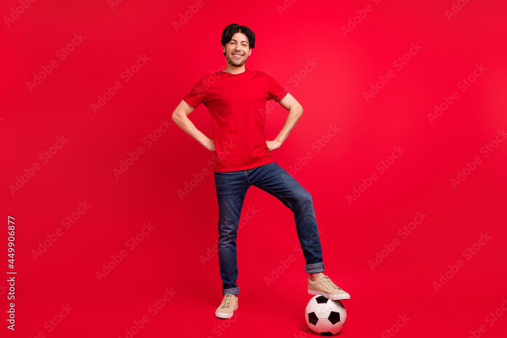 Full length photo of young man happy positive smile play football game sportive isolated over red color background