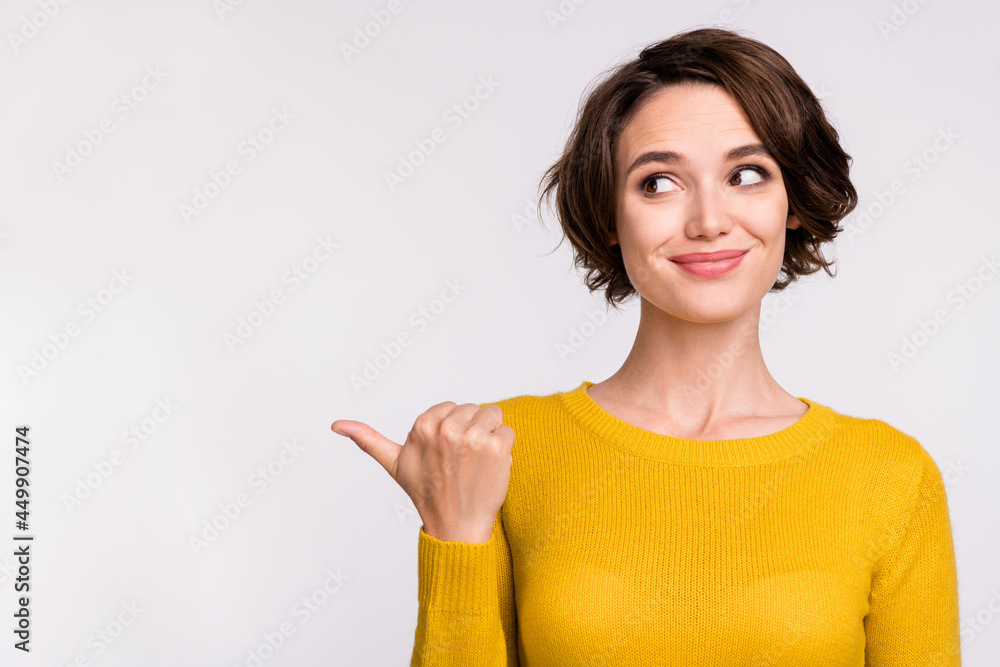 Photo of young girl happy positive smile point thumb empty space ad advice choose isolated over grey color background Photo of young girl happy positive smile point thumb empty space ad advice choose isolated over grey color background