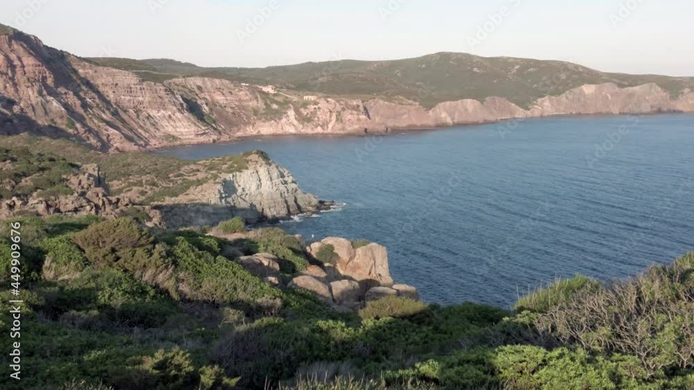 Enchanting wilderness bay with blue sea and green hills and steep cliffs on the sea Enchanting wilderness bay with blue sea and green hills and steep cliffs on the sea