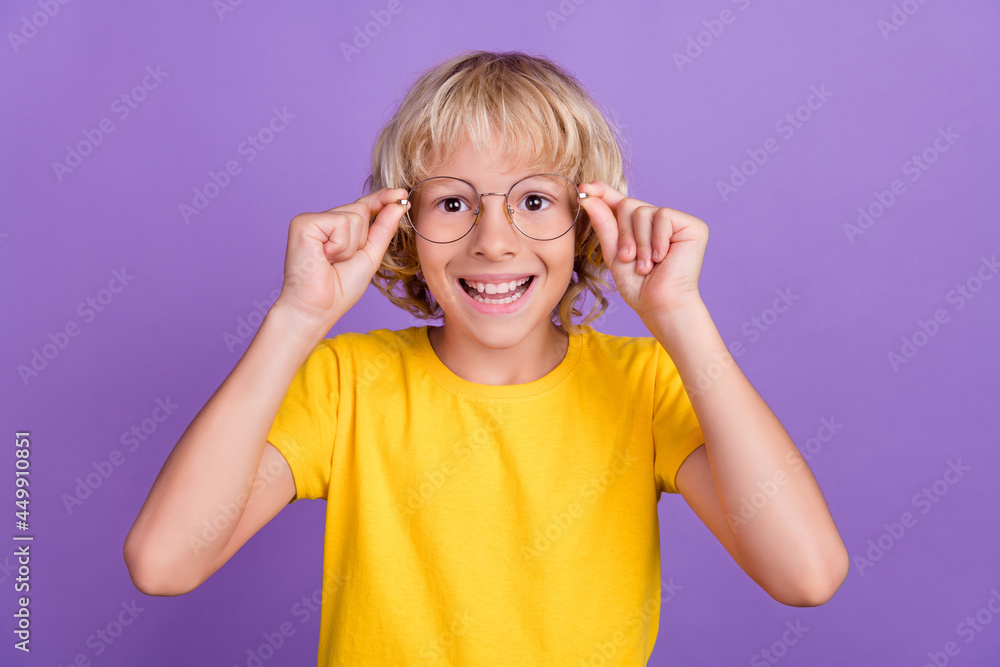 Photo of impressed funny schoolboy wear yellow t-shirt arms spectacles big eyes smiling isolated violet color background Photo of impressed funny schoolboy wear yellow t-shirt arms spectacles big eyes smiling isolated violet color background
