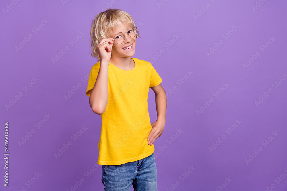 Photo of charming pretty school boy wear yellow t-shirt arm glasses empty space smiling isolated purple color background Photo of charming pretty school boy wear yellow t-shirt arm glasses empty space smiling isolated purple color background