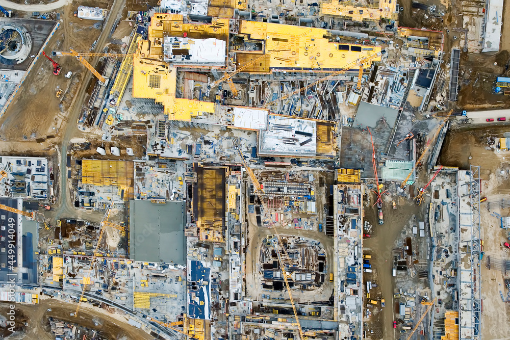 Aerial View of Busy Industrial Construction Site with Workers and Machines (Bulldozers, Cranes), High Resolution