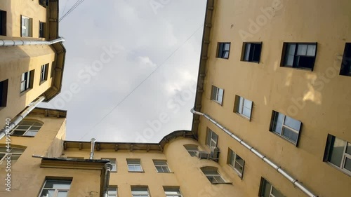 Wallpaper Mural Bottom up view of the yellow house and the sky in a narrow courtyard. Overpopulation in modern cities. Torontodigital.ca