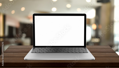 Laptop with blank screen on table with blurred restaurant background