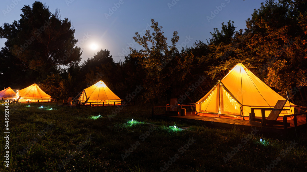 Glamping at night, few glowing tents