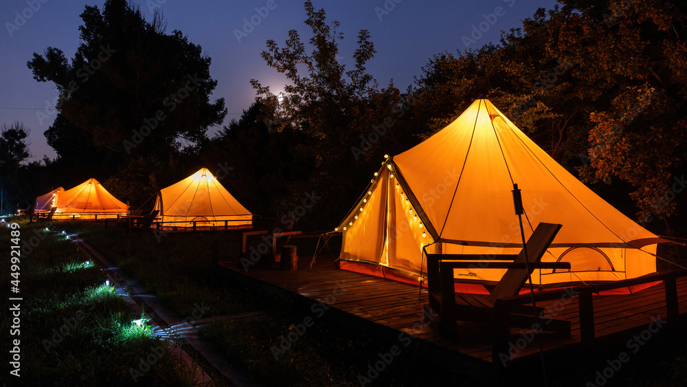 Glamping at night, few glowing tents