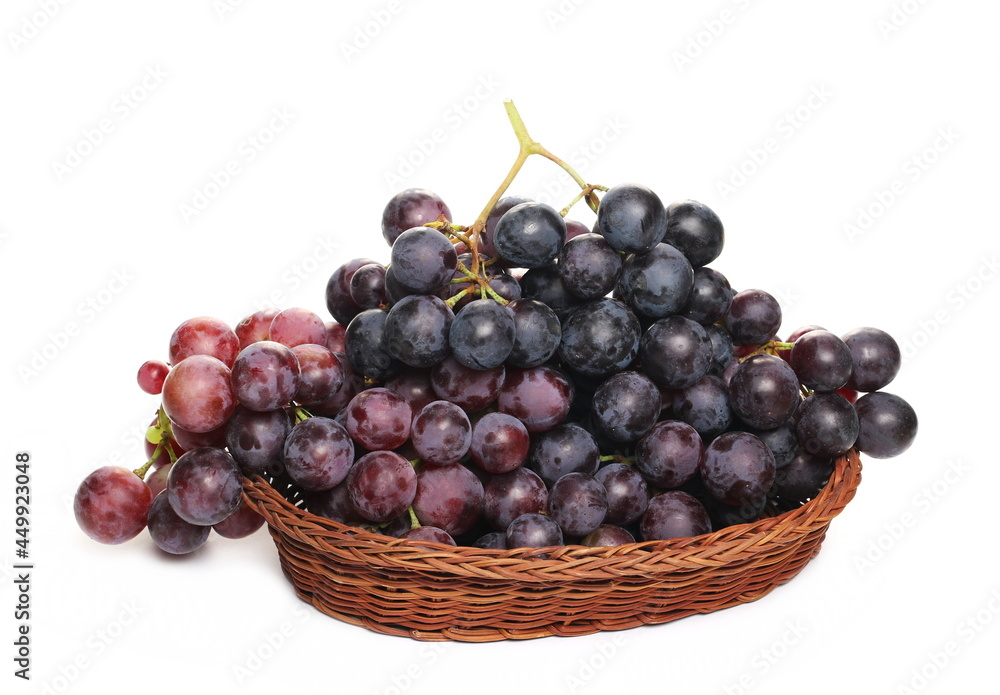 Cardinal grapes in wooden wicker basket, isolated on white background Cardinal grapes in wooden wicker basket, isolated on white background
