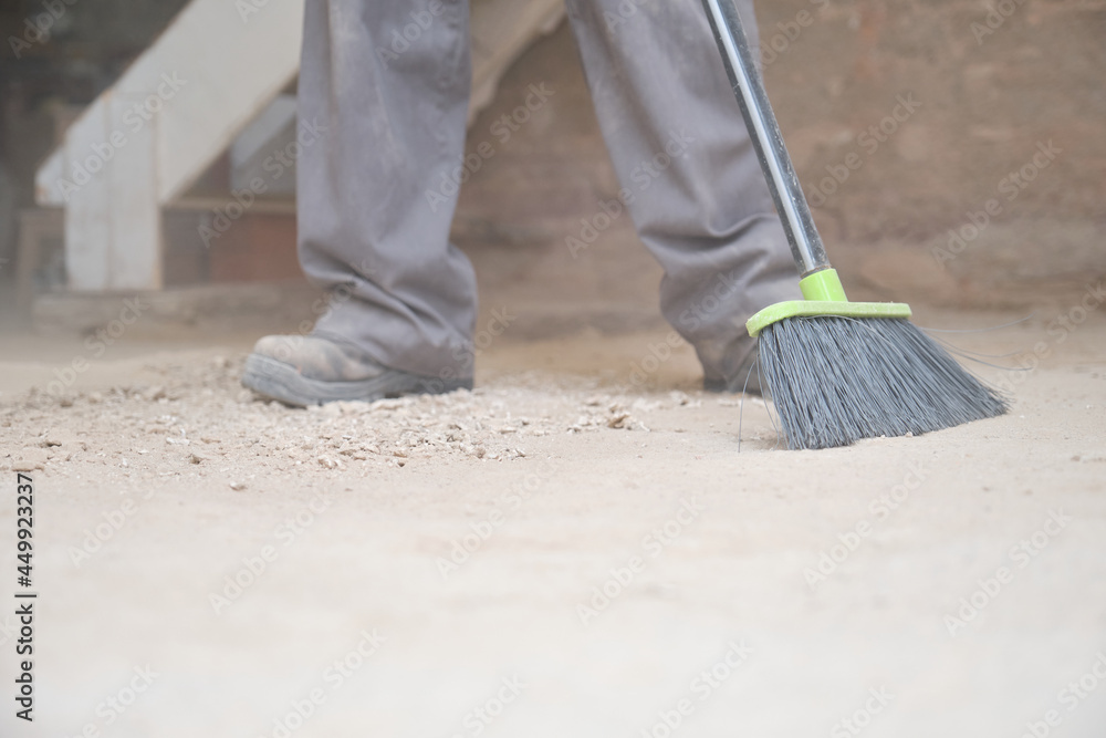 custom made wallpaper toronto digitalUnrecognizable young builder sweeping the floor at a construction site.