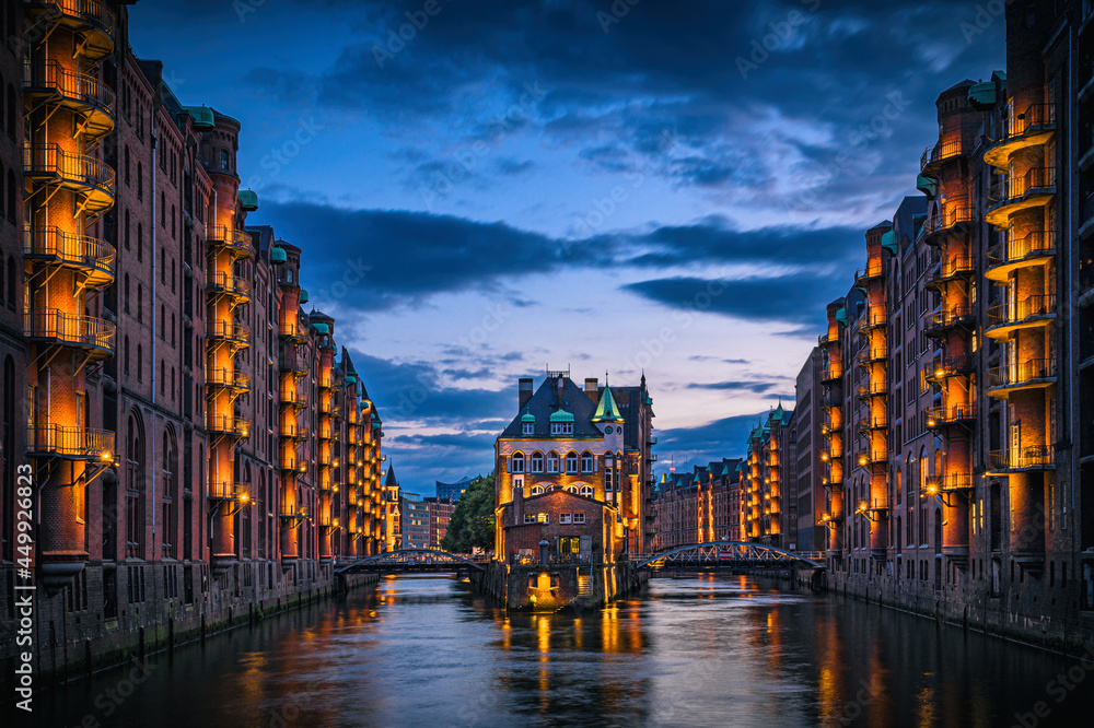 Speicherstadt in Hamburg mit beleuchtetem Wasserschloss am Abend