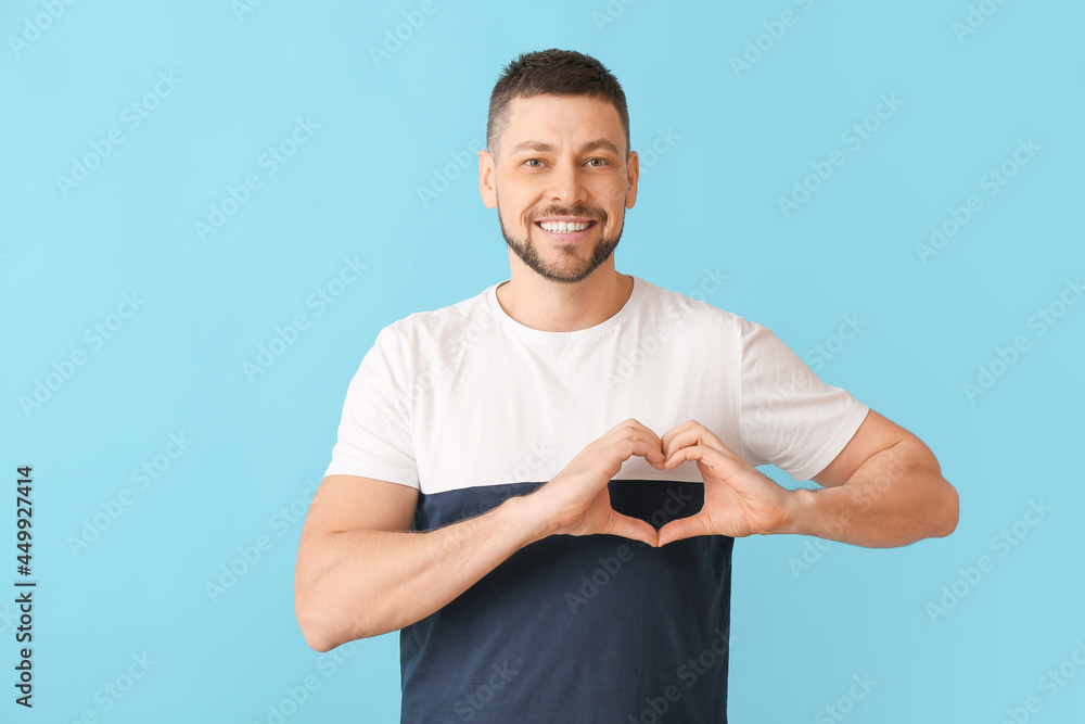 Man making heart with his hands on color background Man making heart with his hands on color background