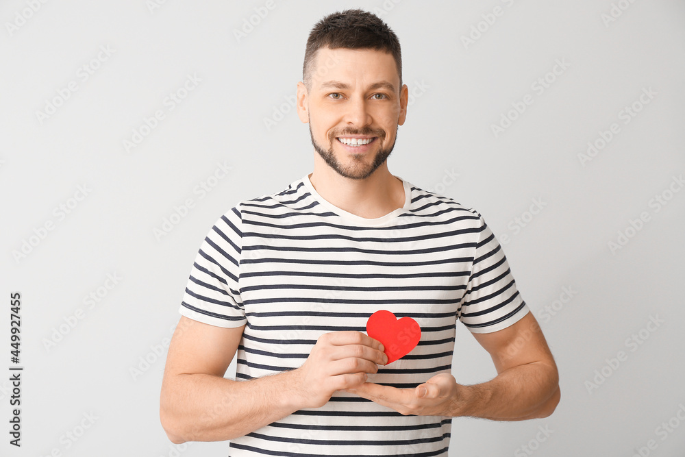 Man with red heart on light background