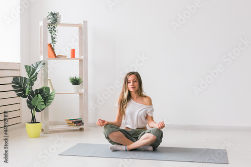 Young woman in the lotus position while meditating. Mindfulness practice, well-being and Self-concept.