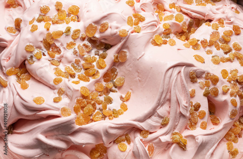 Punch flavour gelato - full frame detail. Close up of pink surface texture of Ice cream covered with pieces of raisins.