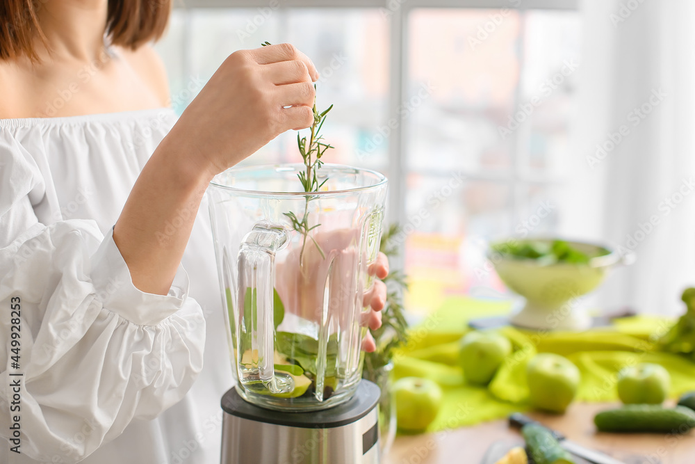 Young woman preparing healthy green smoothie in kitchen, closeup Young woman preparing healthy green smoothie in kitchen, closeup