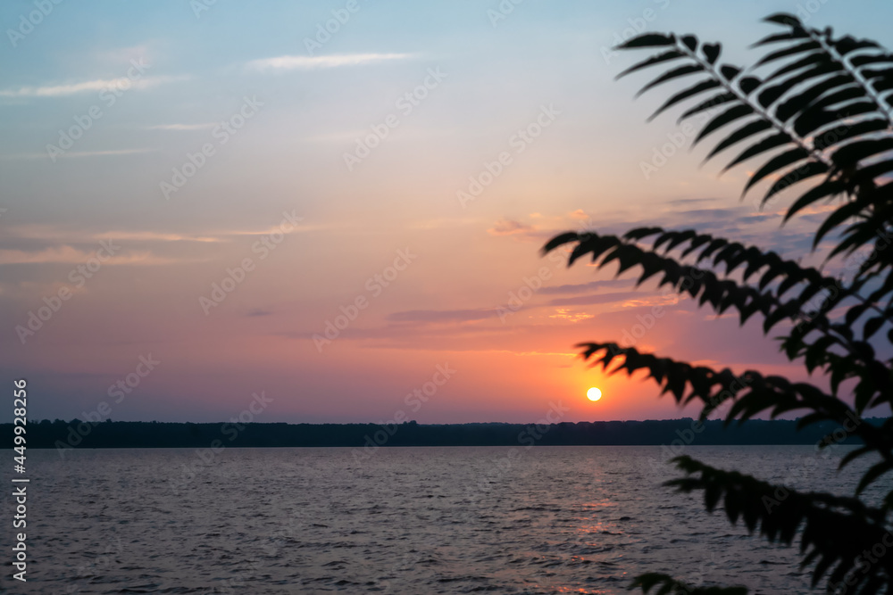Sunset or sunrise on the banks of the wide river of the river.