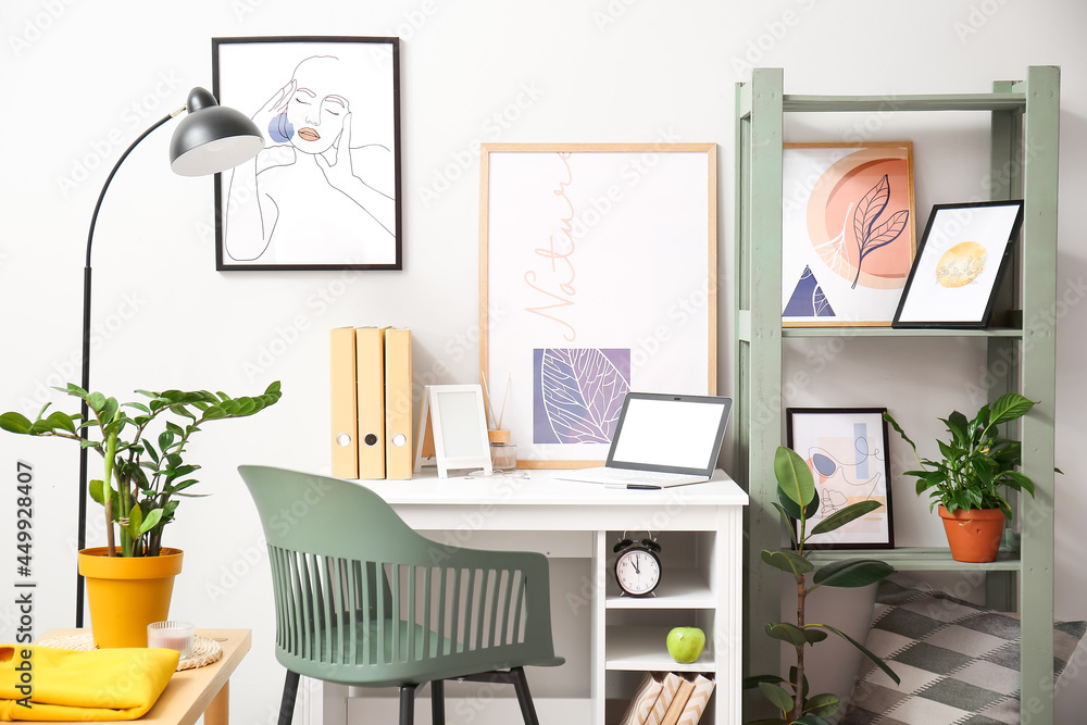 Fototapeta premium Interior of stylish room with modern workplace and pictures