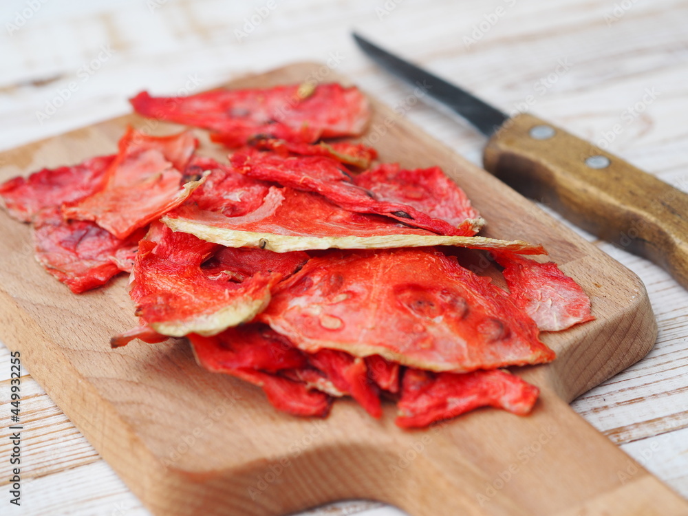 Dried and fresh slices of watermelon on a kitchen board on a wooden white table. Dried and fresh slices of watermelon on a kitchen board on a wooden white table.