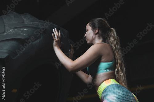 a Colombian girl pushing a wheel inside a gym.