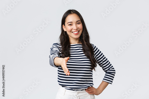 Lifestyle, people emotions and casual concept. Friendly outgoing asian woman extend hand for handshake, have business meeting, say nice to meet you, greet new people in company
