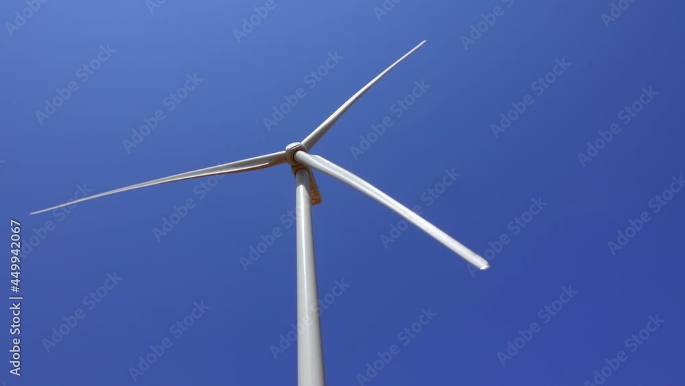 Green energy, a wind turbine against a blue sky in a field in Ukraine, Odessa region Green energy, a wind turbine against a blue sky in a field in Ukraine, Odessa region